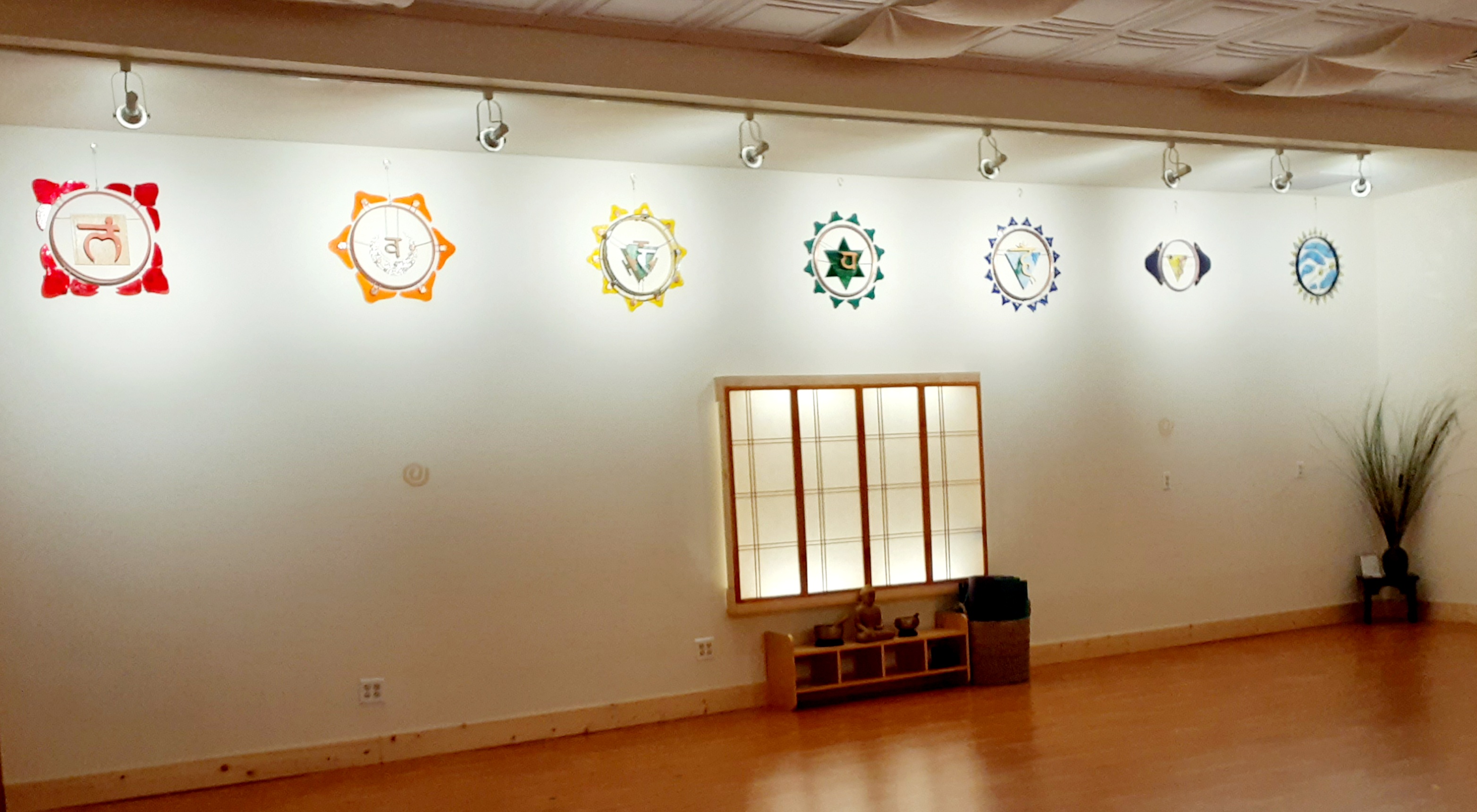 row of glass chakra sculptures on wall